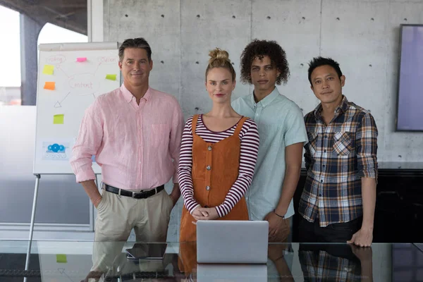 Portrait of multi-ethnic business colleagues standing together in modern office