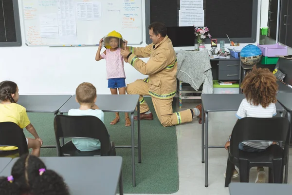 Zijaanzicht Van Een Brandweerman Knielend Terwijl Hij Het Onderwijs Aan — Stockfoto