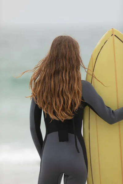 Achteraanzicht Van Vrouwelijke Surfer Permanent Met Surfboard Het Strand — Stockfoto