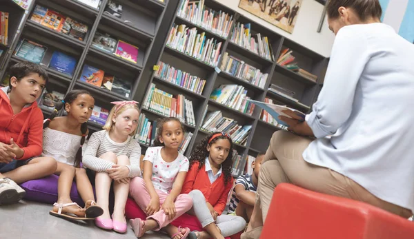 Pohled Školní Děti Které Poslouchají Svého Učitele Vypráví Příběh Knihovně — Stock fotografie