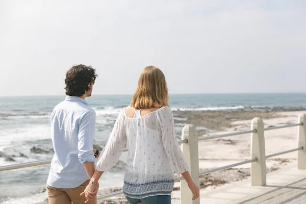 Bakifrån Unga Kaukasiska Par Promenader Hand Hand Strandpromenaden Vid Havet — Stockfoto