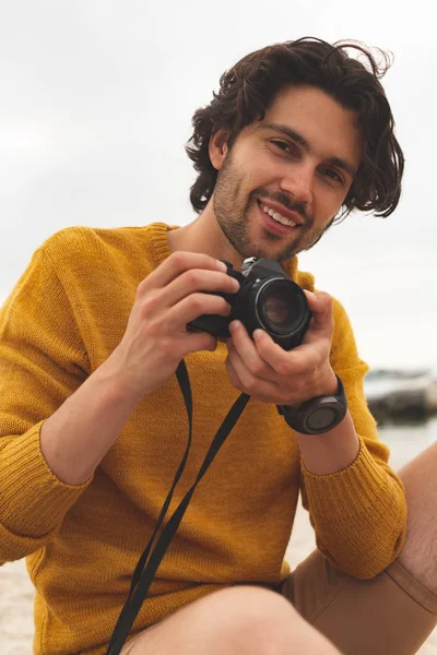 Vorderansicht Eines Jungen Kaukasischen Mannes Mit Digitalkamera Der Strand Sitzt — Stockfoto