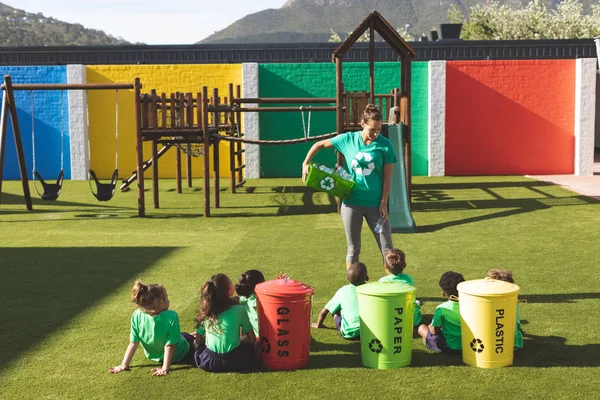 在校园里向专心学生传授绿色能源和回收利用的高加索教师的前面 — 图库照片