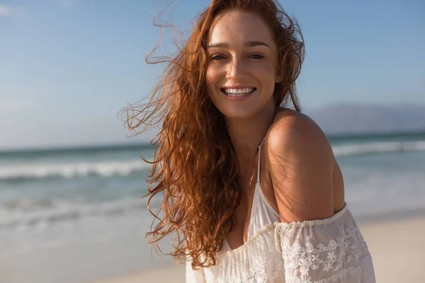 カメラで浜に立って見て美しい幸せな若い白人女の正面 彼女は笑っています — ストック写真