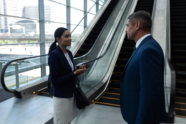 Seitenansicht Von Geschäftsmann Und Geschäftsfrau Die Der Nähe Einer Rolltreppe — Stockfoto