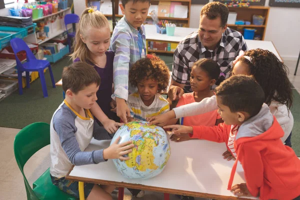 在学校的课堂上 老师向他的学校的孩子们展示地球 — 图库照片