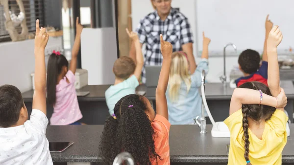 Widok Tyłu Szkoły Dzieci Podnoszenie Rękę Podczas Nauczyciel Zadawanie Pytań — Zdjęcie stockowe