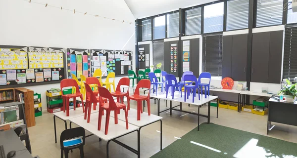 学校空教室的桌子上布置的彩椅的正面视图 — 图库照片