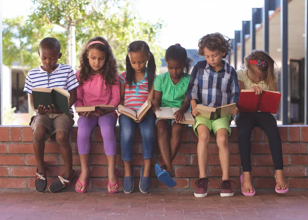 Vooraanzicht Van Multi Etnische Studenten Lezen Boek Zittend Bakstenen Muur — Stockfoto