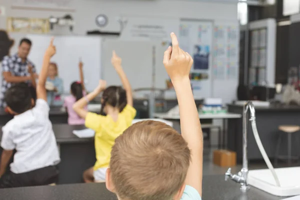 Widok Tyłu Szkoły Dzieci Podnoszenie Rękę Klasie Szkole Nauczycielem Tle — Zdjęcie stockowe