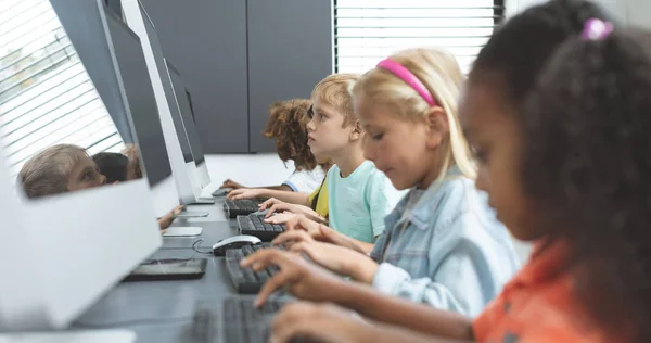 学校孩子在学校的电脑室里用键盘录音的侧视图 — 图库照片