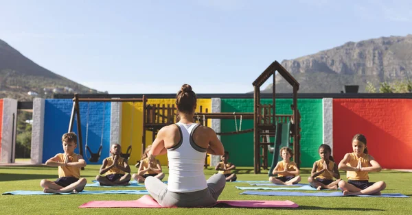 Vista Trasera Del Entrenador Caucásico Enseñando Yoga Los Estudiantes Estera —  Fotos de Stock