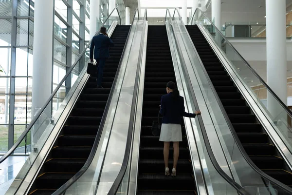 Visão Traseira Empresário Empresária Movendo Para Cima Diferentes Escadas Rolantes — Fotografia de Stock