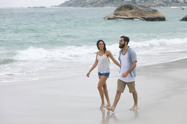 手拉手在海滩上散步的情侣的正面看法 — 图库照片