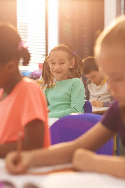 Vooraanzicht Van Kaukasisch School Meisje Kijken Naar Camera Zittend Aan — Stockfoto