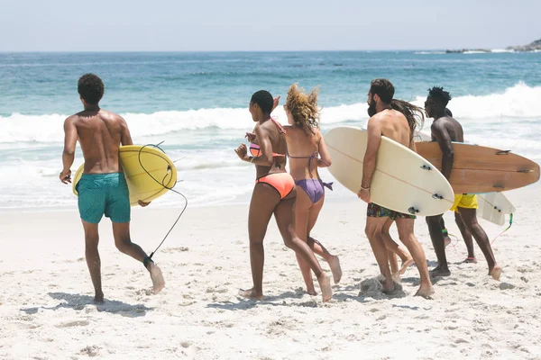 Rear View Multi Ethnic Group Friends Holding Surfboard Running Sea — стоковое фото