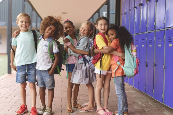 Vista Frontal Crianças Escola Feliz Corredor Segurando Juntos Braços — Fotografia de Stock