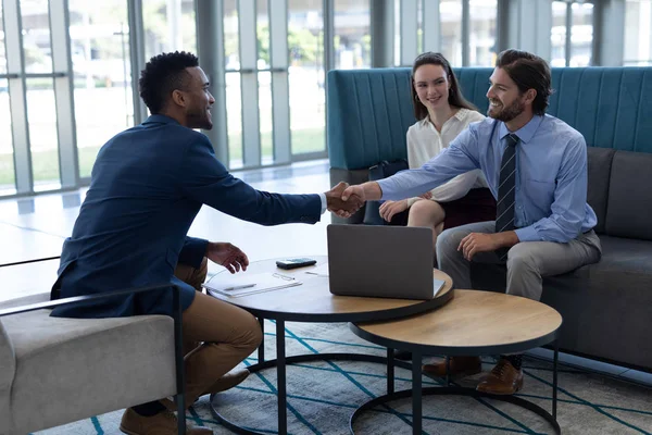 Vista Lateral Jóvenes Empresarios Multiétnicos Estrechándose Mano Vestíbulo Oficina — Foto de Stock