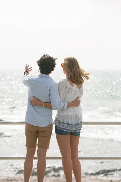 在阳光明媚的日子里 在海滨长廊上 年轻的高加索夫妇站在海边的后视 — 图库照片