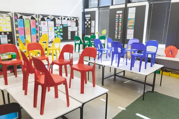 学校空教室的桌子上布置的彩椅的正面视图 — 图库照片