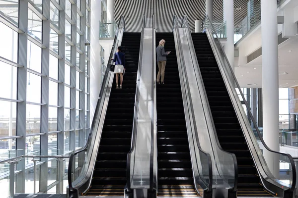 Rear View Young Multi Ethnic Businesswomen Using Escalator Modern Office — Stock Photo, Image