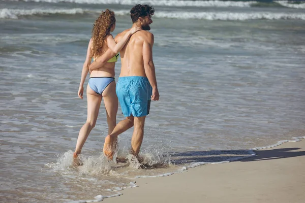 Vista Trasera Pareja Caucásica Caminando Por Océano Con Los Brazos —  Fotos de Stock