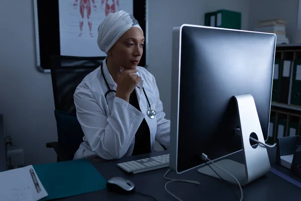 Взгляд Вдумчивой Взрослой Женщины Врача Смешанной Расы Работающей Компьютером Клинике — стоковое фото