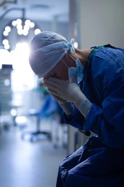 Zijaanzicht Van Een Verstoorde Vrouwelijke Chirurg Zittend Operatie Bed Houdt — Stockfoto