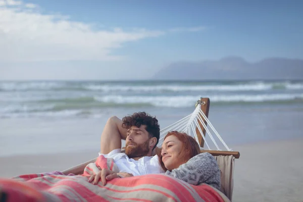 在海滩上的吊床上放松的快乐的高加索夫妇的前面 她把脸靠在他的肩膀上 — 图库照片