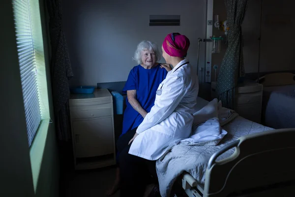 Hastane Odasında Yatağında Otururken Olgun Bir Karışık Yarış Kadın Doktor — Stok fotoğraf