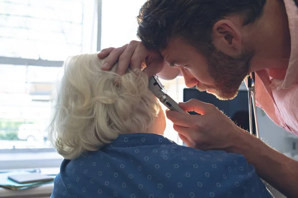 Zijaanzicht Van Kaukasische Mannelijke Arts Controlerend Hoger Vrouwelijk Geduldige Oor — Stockfoto