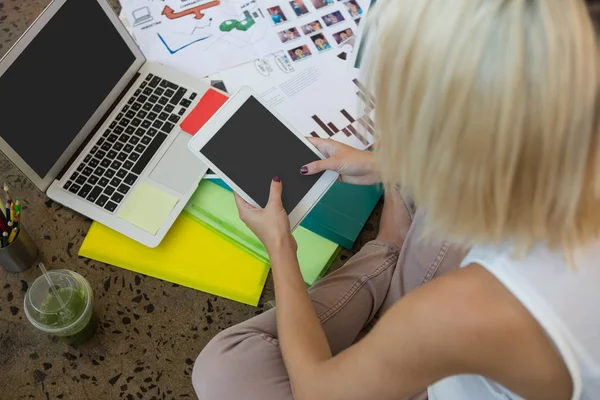年轻的白种人金发碧眼的女人用数字平板电脑坐在地板上的创意办公室的高视角 — 图库照片