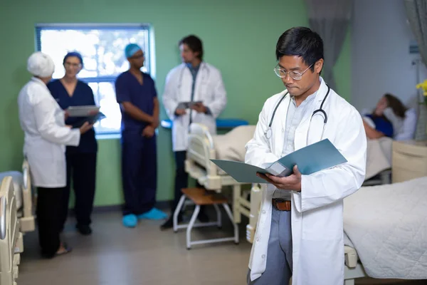Front View Confident Asian Male Doctor Looking Medical Report Clinic — Stock Photo, Image