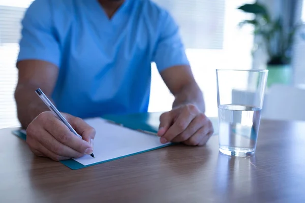 Sezione Media Della Scrittura Chirurgo Maschile Sulla Cartella Clinica Ospedale — Foto Stock