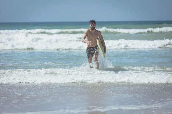 Vista Frontal Jovem Surfista Masculino Com Uma Prancha Amarela Correndo — Fotografia de Stock