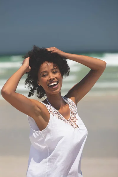 在阳光明媚的日子里 快乐的年轻混血女子站在海滩上摆姿势的肖像 她面带微笑 看着照相机 — 图库照片
