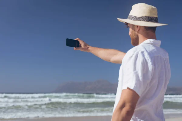 Hátulnézet Kaukázusi Férfi Beszél Selfie Állandó Strandon Egy Napsütéses Napon — Stock Fotó