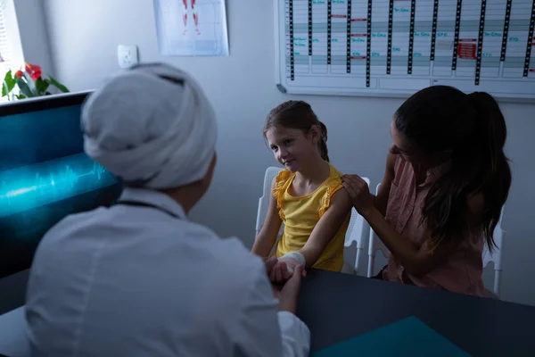 Bakifrån Mognat Blandad Ras Kvinnlig Läkare Undersöker Flicka Hand Kliniken — Stockfoto