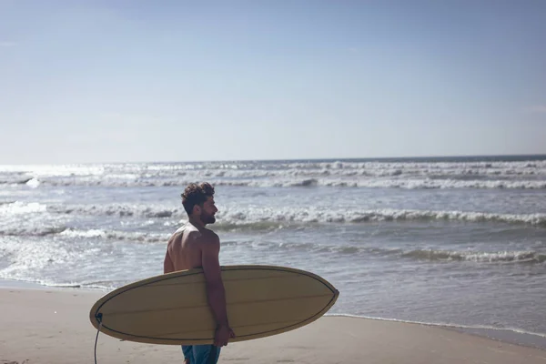 Güneşli Kumsalda Genç Beyaz Erkek Sörfçü Bir Sörf Tahtası Konumu — Stok fotoğraf