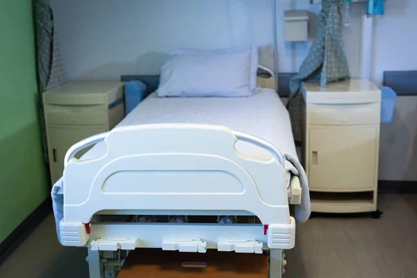 入院中の空のベッドとキャビネットの正面図 — ストック写真
