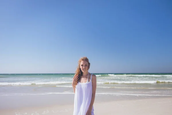 晴れた日にビーチに立っている美しい白人女性の肖像画 彼女は笑顔とカメラ目線 — ストック写真