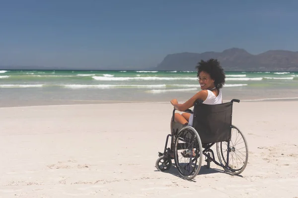 美丽的年轻混血女子的肖像禁用坐在轮椅上在海滩上 她面带微笑 看着照相机 — 图库照片