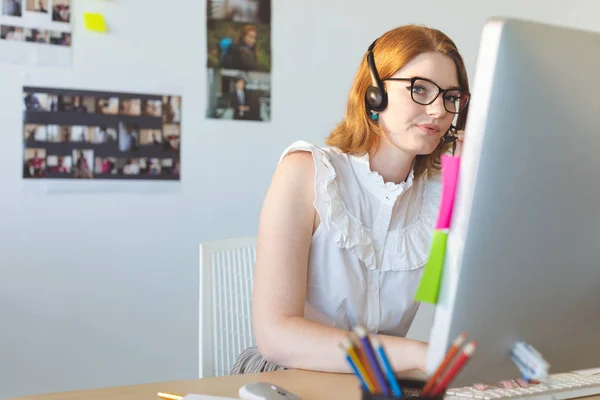 Front View Young Caucasian Female Graphic Designer Talking Headphone While — Stock Photo, Image