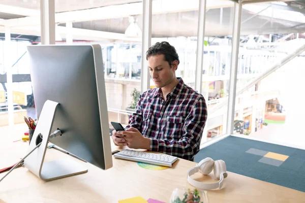 現代のオフィスの机で携帯電話を使用して白人男性グラフィックデザイナーの正面図 — ストック写真