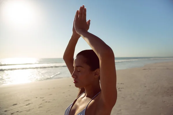 美丽的女人在沙滩上做瑜伽 — 图库照片