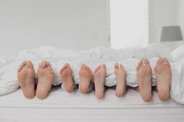 Vooraanzicht Van Familie Voeten Onder Deken Bed Slaapkamer Thuis — Stockfoto