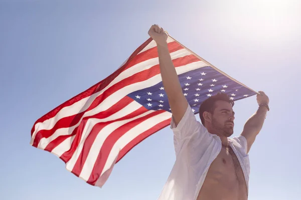 Güneş Işığında Sahilde Amerikan Bayrağı Sallayan Genç Kafkas Adamın Düşük — Stok fotoğraf