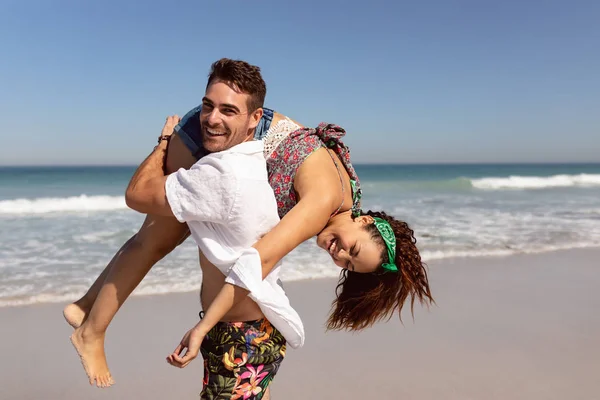 Vista Lateral Homem Feliz Carregando Mulher Nos Ombros Praia Sol — Fotografia de Stock