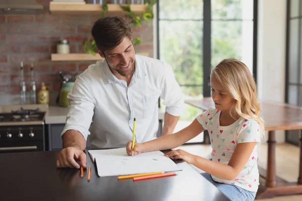 快適な家庭で娘の宿題を手伝う白人の父親の正面図 — ストック写真