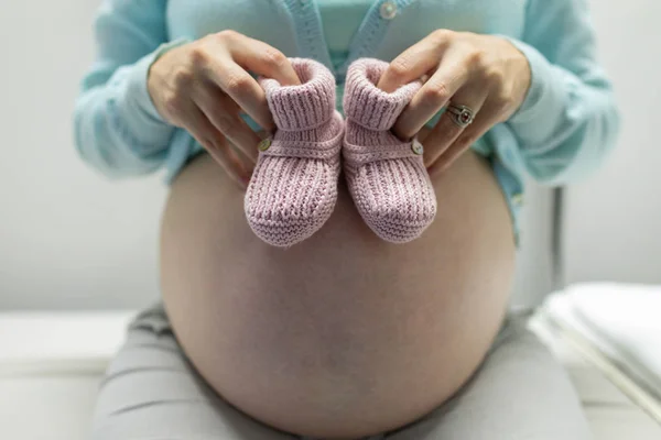 Mid Section Pregnant Woman Holding Baby Shoes Examination Room Hospital — Stock Photo, Image